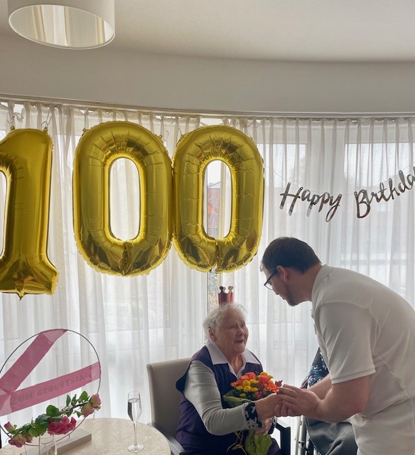 Pfleger gratuliert Geburtstagskind auf deren 100. Geburtstag im Haus Husemann