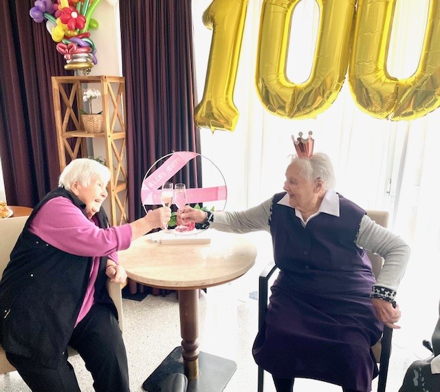 Mitbewohnerin stößt mit Geburtstagskind an auf deren 100. Geburtstag im Haus Husemann