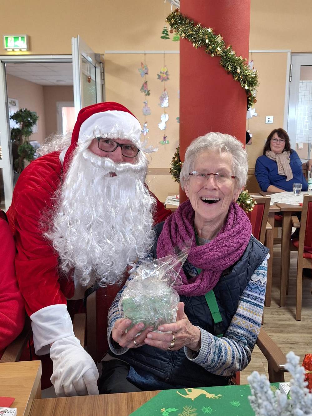 Der Nikolaus verteilt Geschenke bei der Weihnachtsfeier in der Tagespflege Mondorf