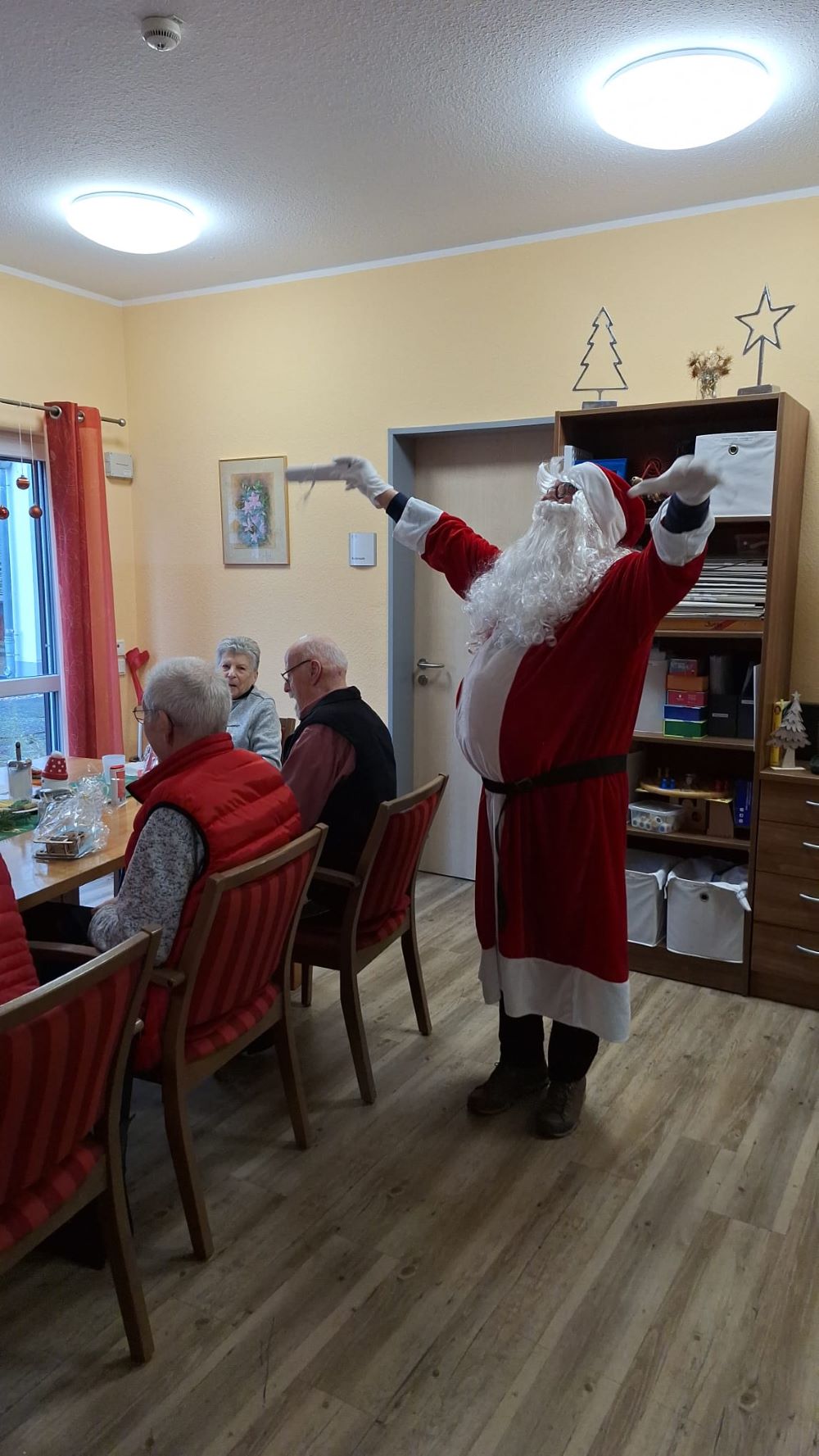 Der Nikolaus verteilt Geschenke bei der Weihnachtsfeier in der Tagespflege Mondorf