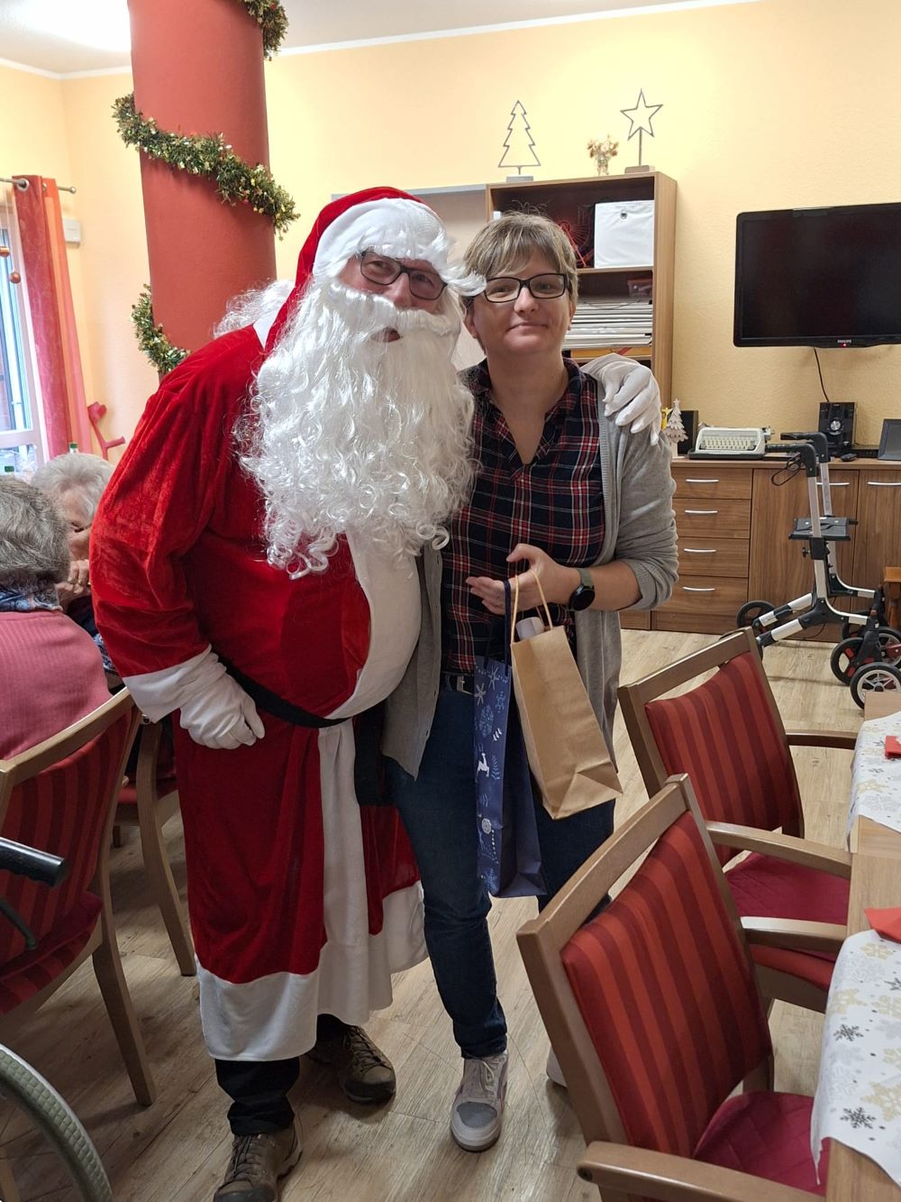 Der Nikolaus verteilt Geschenke bei der Weihnachtsfeier in der Tagespflege Mondorf